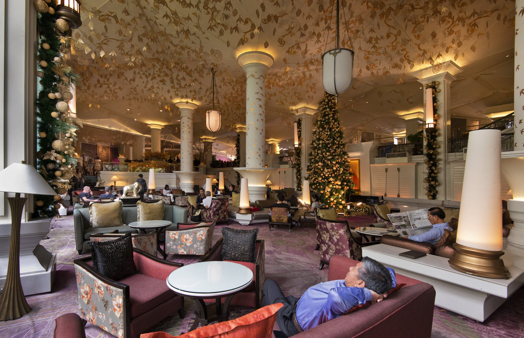 The lobby of the original Dusit Thani hotel in Bangkok, with gold columns and a Christmas tree